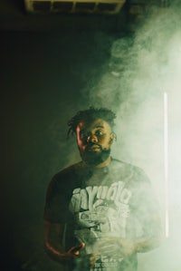 a man with a beard standing in front of smoke
