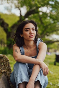 a young woman sitting on a bench in a park