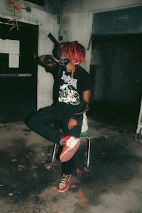 a person with red hair sitting on a chair
