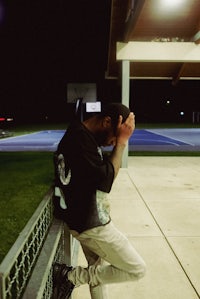 a man leaning against a railing at night