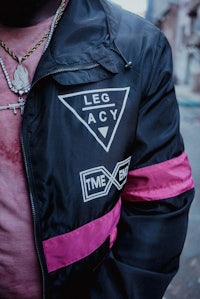 a man wearing a black jacket with pink stripes