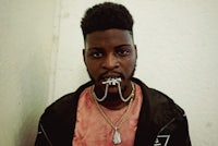 a man wearing a jacket with a chain around his neck